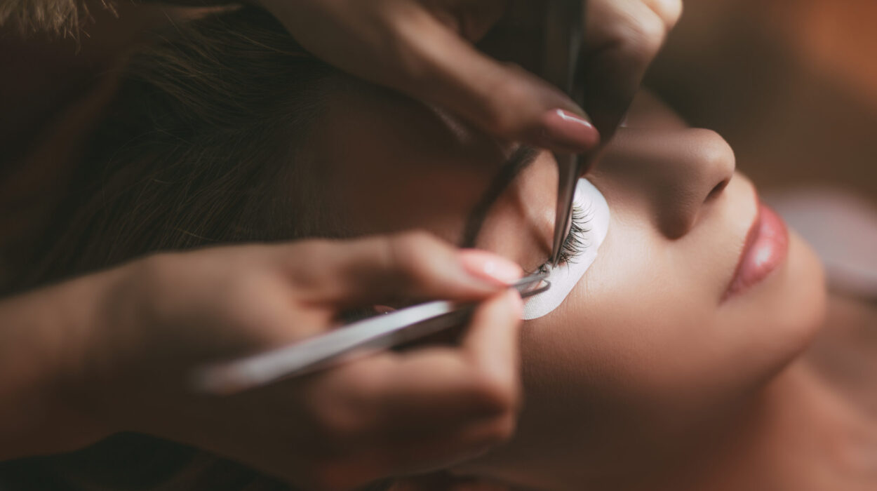 Close up of a beautician applying extended eyelashes to model.