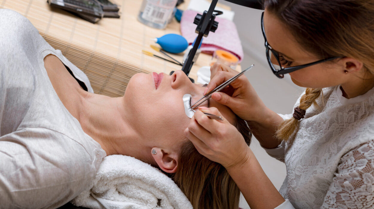 Beautician applying extended eyelashes to model at the beauty salon.