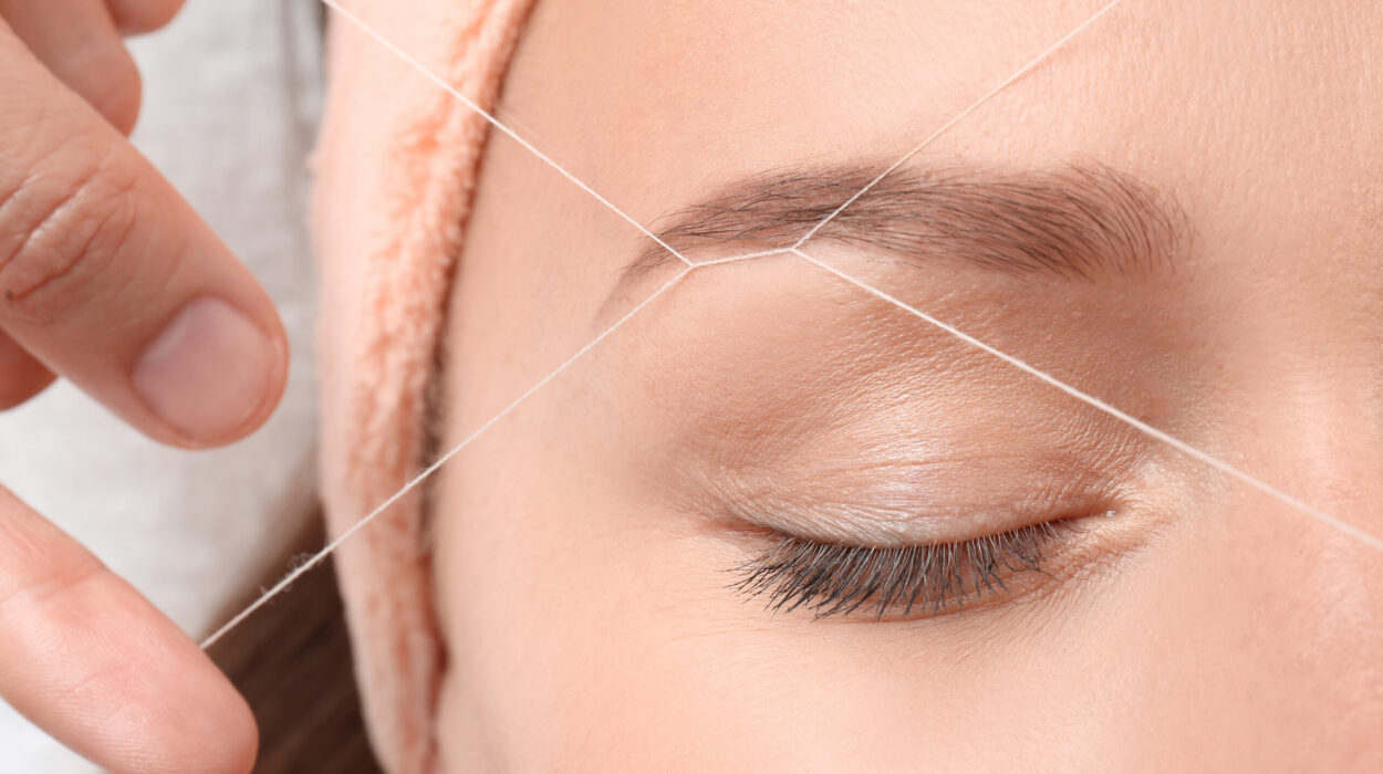 Young woman having eyebrow correction procedure in beauty salon, closeup